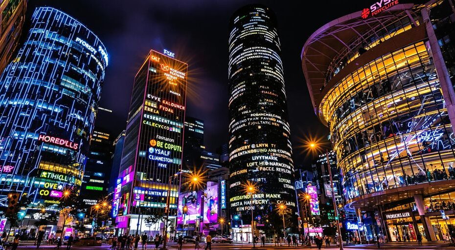 都市の夕方のスカイライン、輝く構造物とダイナミックなネオンの色合い。